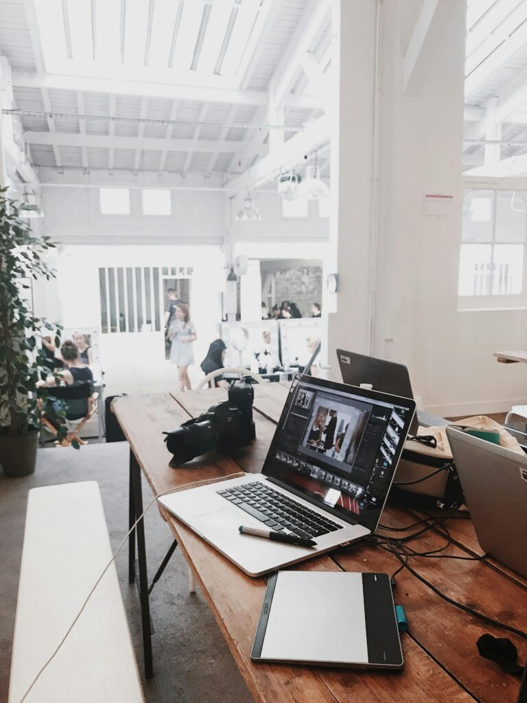 pexels-photo-699459-699459 A bright, modern workspace featuring laptops, a camera, and a drawing tablet in an indoor office.